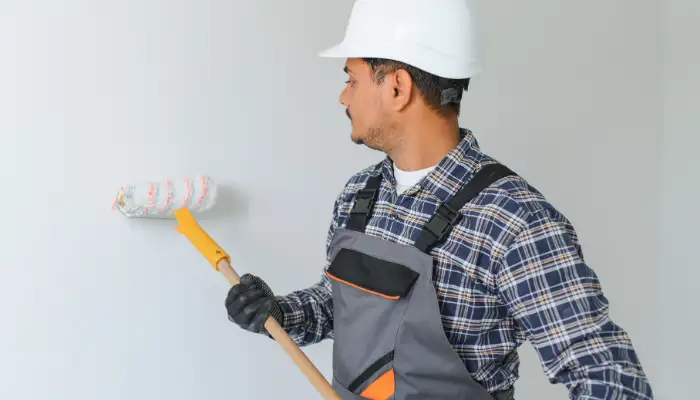 Duvar boyama ustasinin ic mekanda boya uygulamasi yaptigi calisma